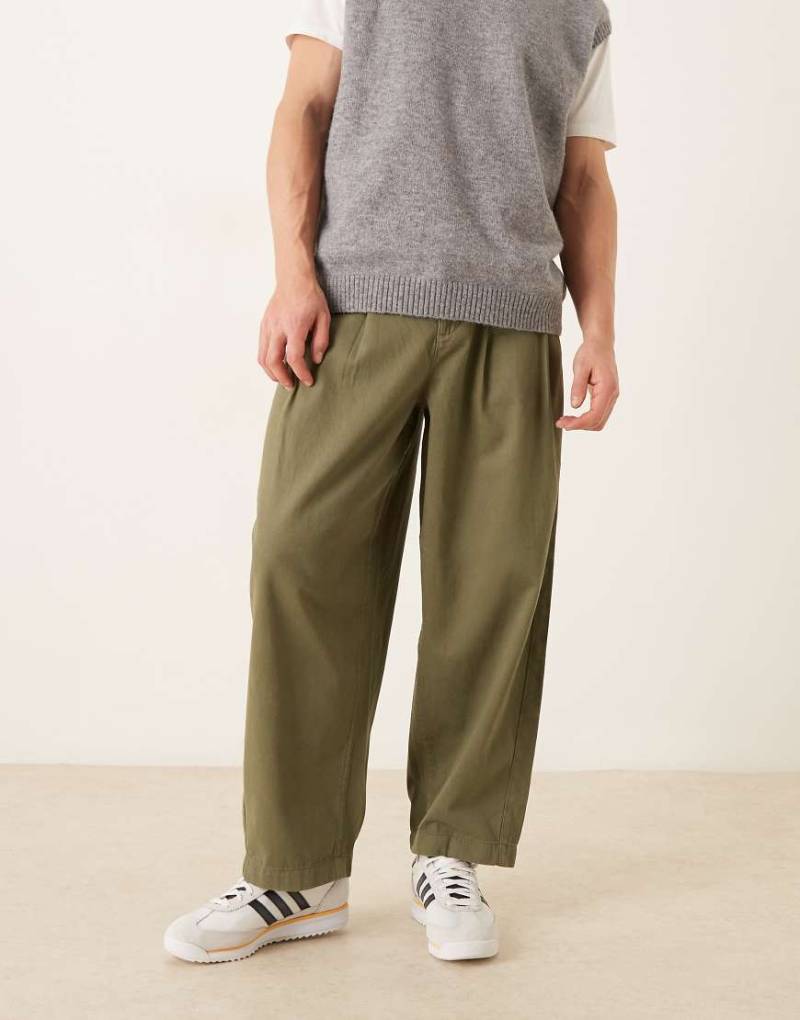 ASOS DESIGN - Schmal zulaufende Oversized-Chinohose in Khaki-Grün von ASOS DESIGN