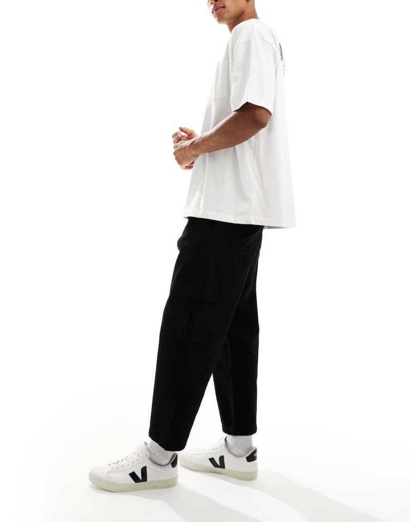 ASOS DESIGN - Schmal zulaufende Relaxed Fit Cargohose in Schwarz mit Bundfalten von ASOS DESIGN