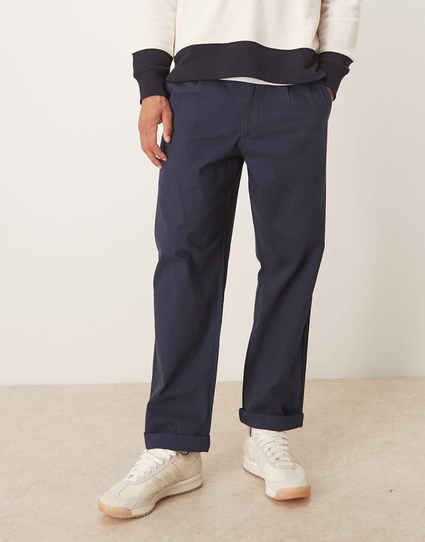 ASOS DESIGN - Schmal zulaufende Relaxed-Fit-Chinohose in Marineblau mit Falten von ASOS DESIGN