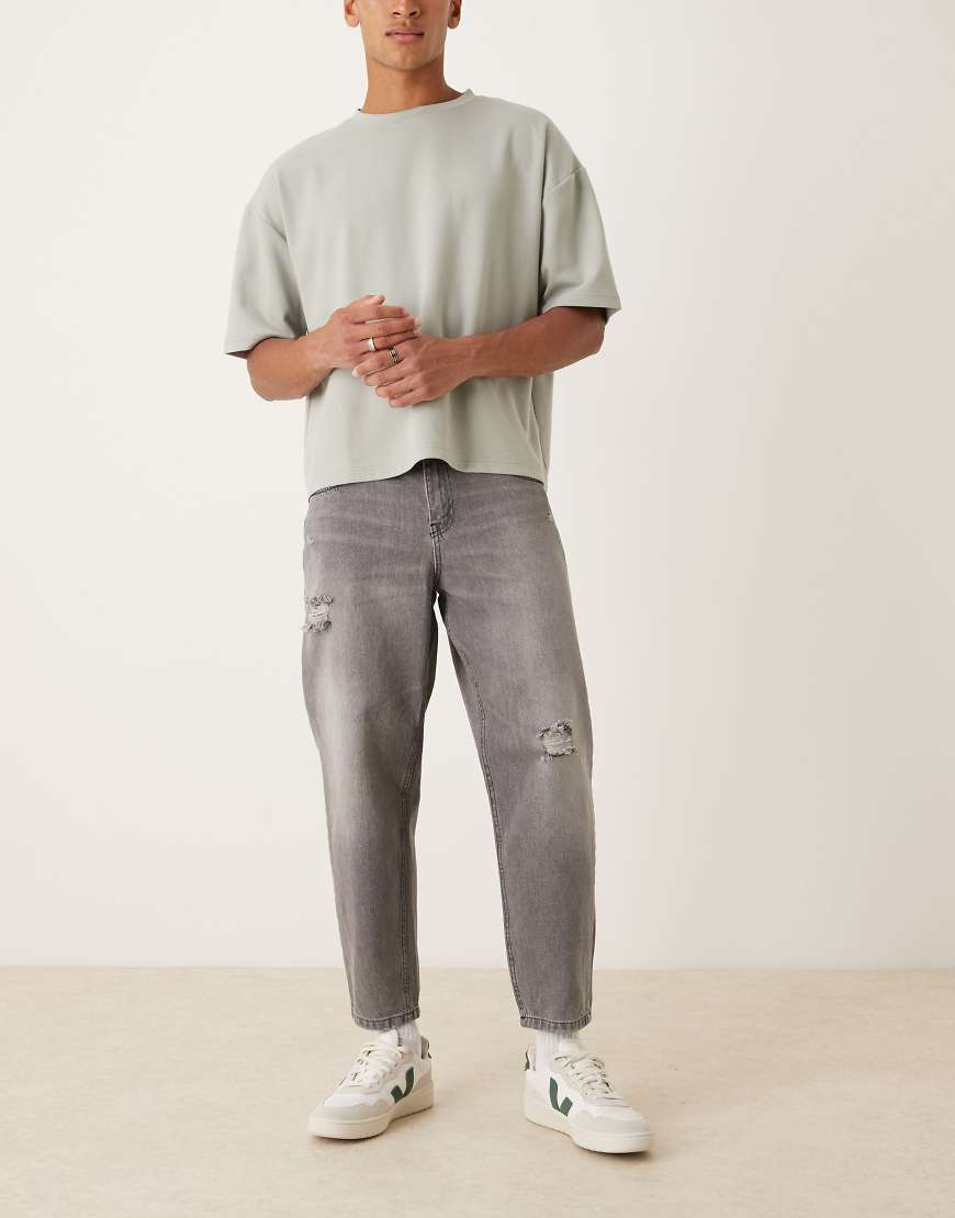 ASOS DESIGN - Schmal zulaufende Relaxed-Fit-Jeans in schwarzer Waschung mit Zierrissen von ASOS DESIGN