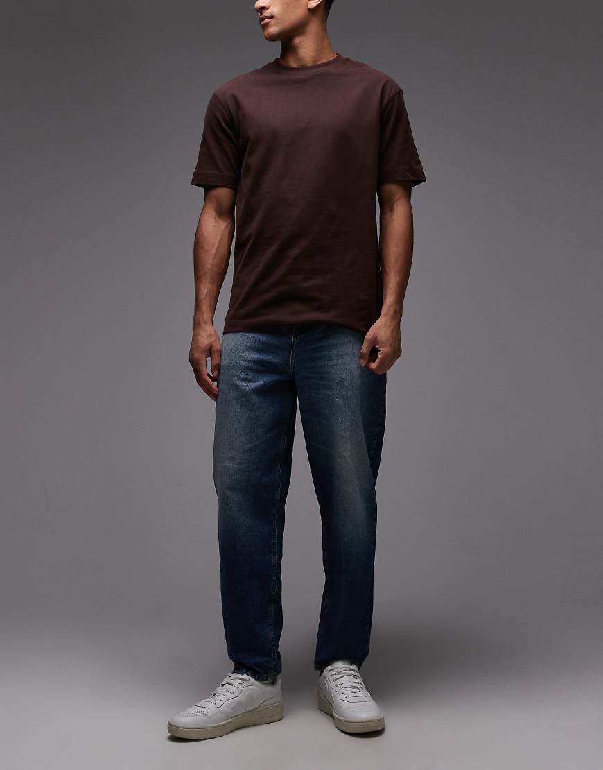 ASOS DESIGN - Schmal zulaufende Relaxed-Jeans mit lockerem Schnitt in Indigoblau von ASOS DESIGN