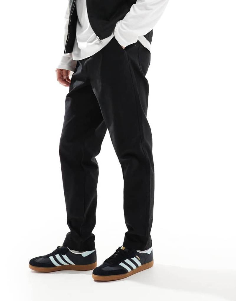 ASOS DESIGN - Schmal zulaufende Schlupfhose in Schwarz mit Tasche und Logo-Aufnäher hinten von ASOS DESIGN