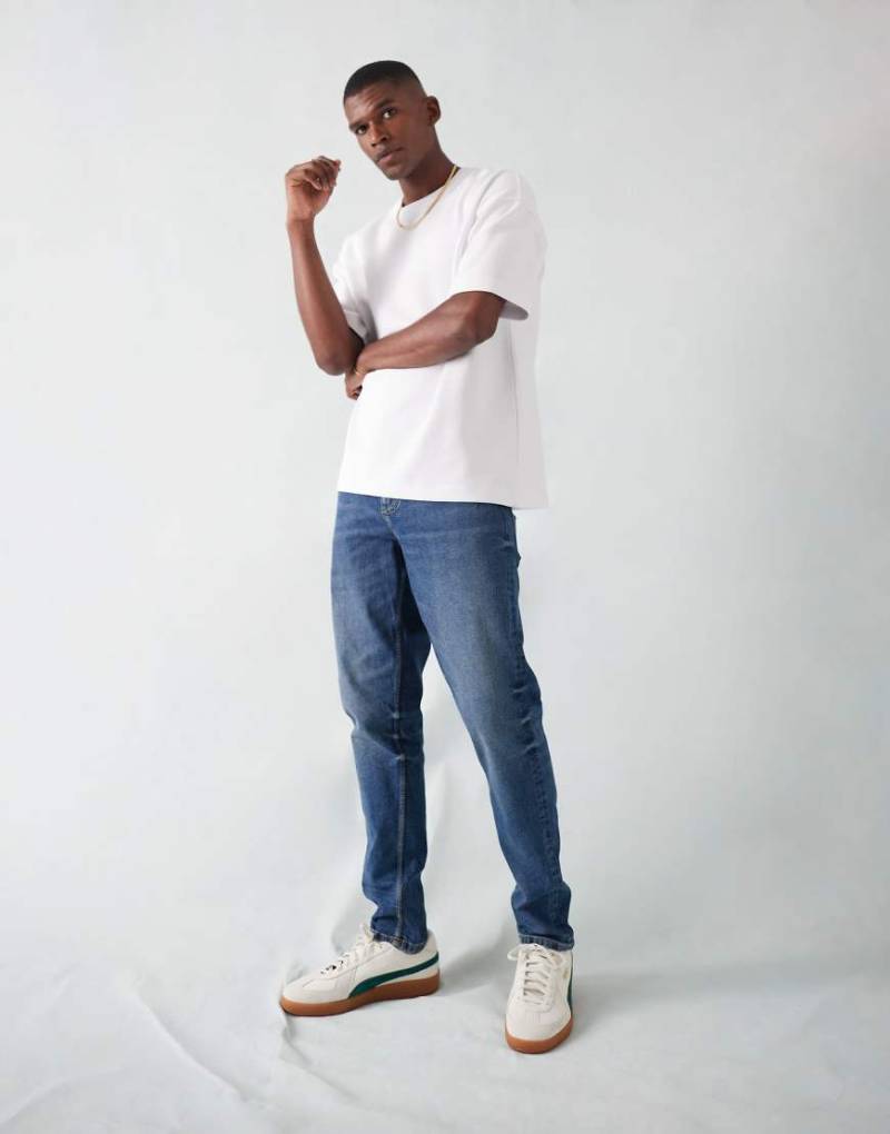 ASOS DESIGN - Schmal zulaufende Stretch-Jeans in dunkler Waschung-Blau von ASOS DESIGN