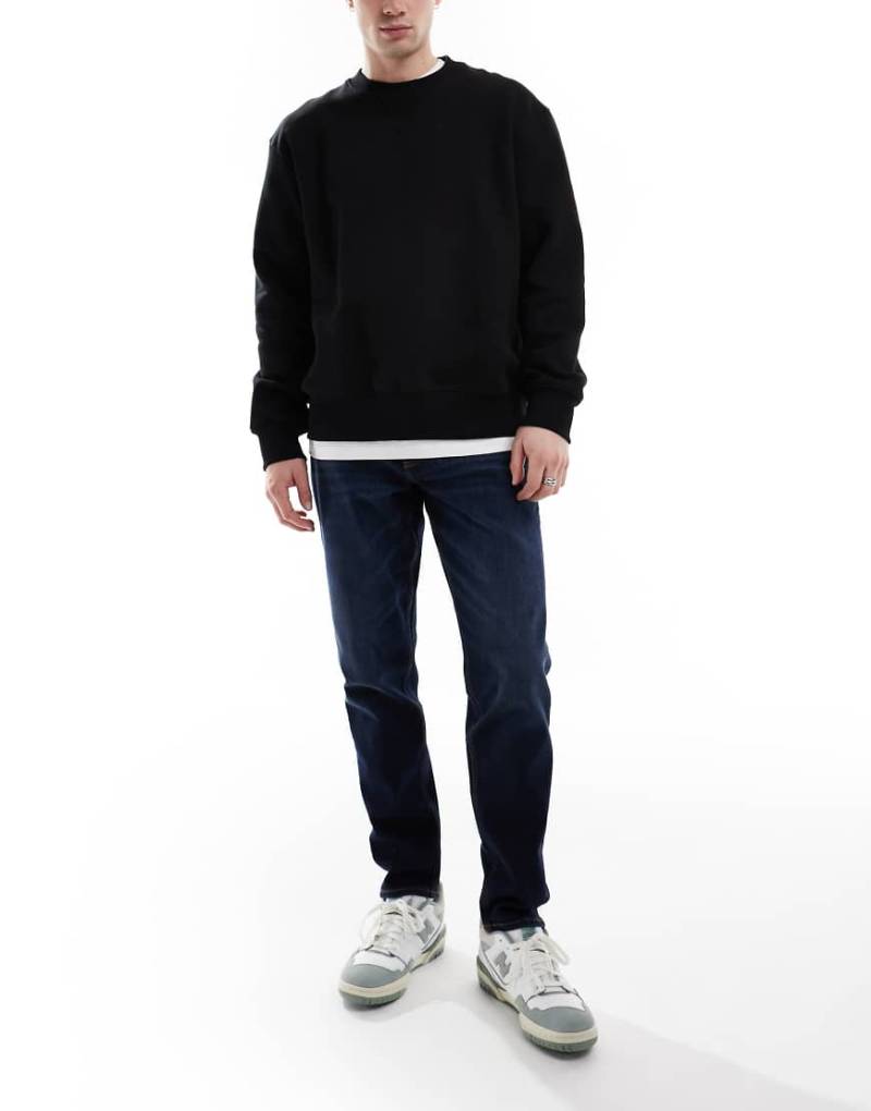 ASOS DESIGN - Schmal zulaufende Stretch-Jeans in dunkler Waschung-Blau von ASOS DESIGN