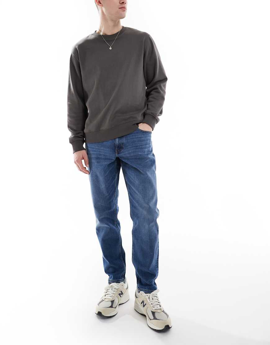 ASOS DESIGN - Schmal zulaufende Stretch-Jeans in mittlerer Waschung-Blau von ASOS DESIGN
