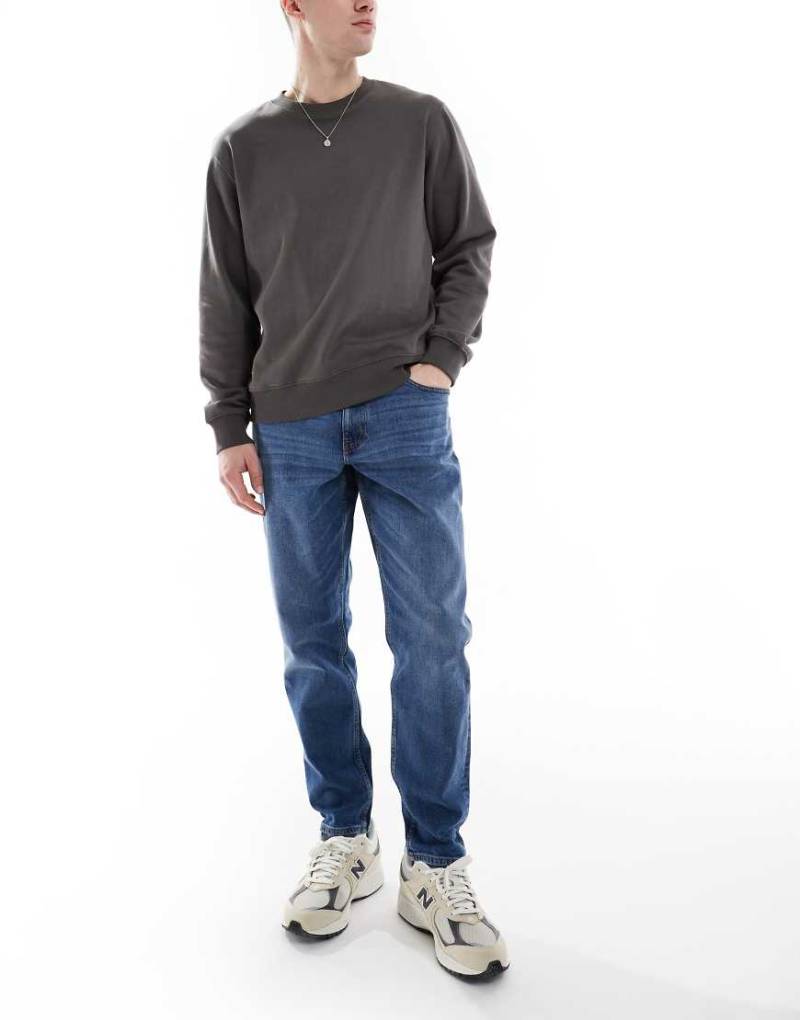 ASOS DESIGN - Schmal zulaufende Stretch-Jeans in mittlerer Waschung-Blau von ASOS DESIGN