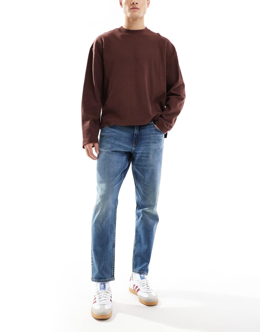 ASOS DESIGN - Schmal zulaufende Stretch-Jeans in verwaschenem Dunkelblau von ASOS DESIGN