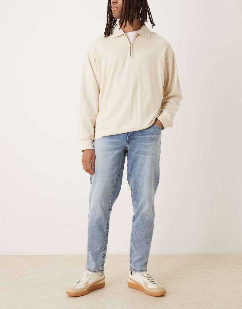 ASOS DESIGN - Schmal zulaufende Stretch-Jeans in verwaschenem Mittelblau von ASOS DESIGN