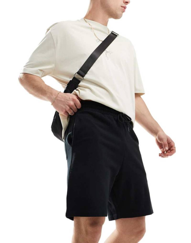 ASOS DESIGN - Schmale, mittellange Shorts in Schwarz von ASOS DESIGN