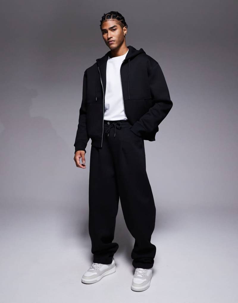 ASOS DESIGN - Schwere Jogginghose in Schwarz aus Stoff in Neoprenoptik, mit weitem Bein und Abnähern von ASOS DESIGN