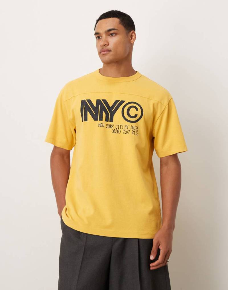 ASOS DESIGN - Schweres, locker geschnittenes T-Shirt in verwaschenem Gelb mit NYC-Grafikprint von ASOS DESIGN