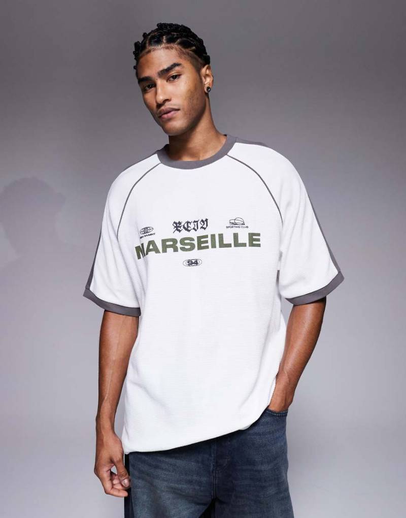 ASOS DESIGN - Schweres Oversize-T-Shirt in Weiß mit Raglanärmeln, Waffelstruktur, City-Textgrafik und Paspelierung von ASOS DESIGN