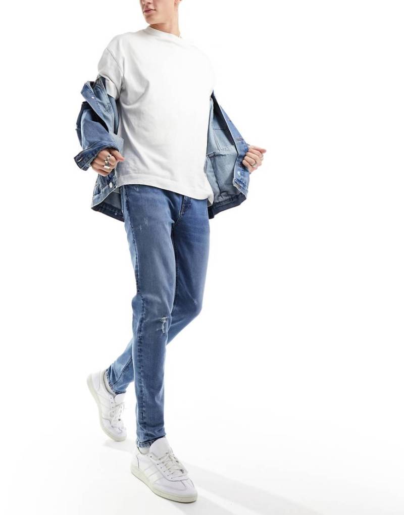 ASOS DESIGN - Skinny-Jeans in dunkelblauer Waschung mit Knierissen von ASOS DESIGN