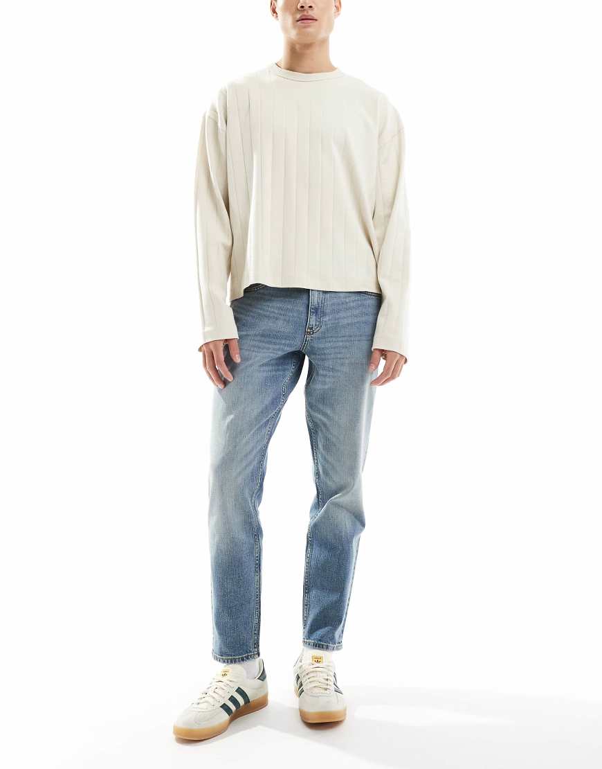 ASOS DESIGN - Stretch-Karottenjeans in verwaschenem Mittelblau ASOS DESIGN - Stretch-Karottenjeans in verwaschenem Mittelblau von ASOS DESIGN