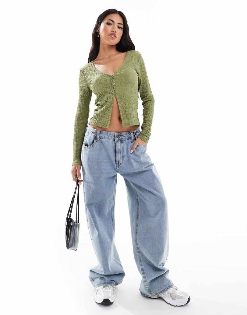 ASOS DESIGN - Strukturierte Strickjacke in Khaki mit V-Ausschnitt und geschlitzter Vorderseite-Grün von ASOS DESIGN