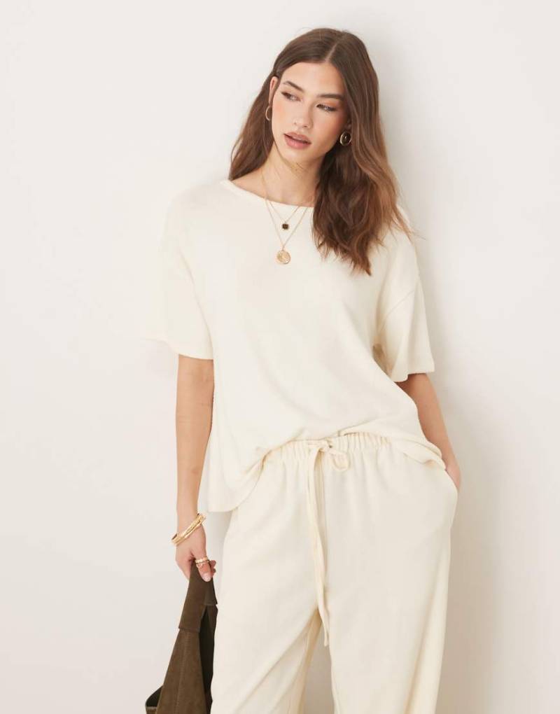 ASOS DESIGN - Strukturiertes Strick-T-Shirt in Creme mit Zipfelsaum-Weiß von ASOS DESIGN