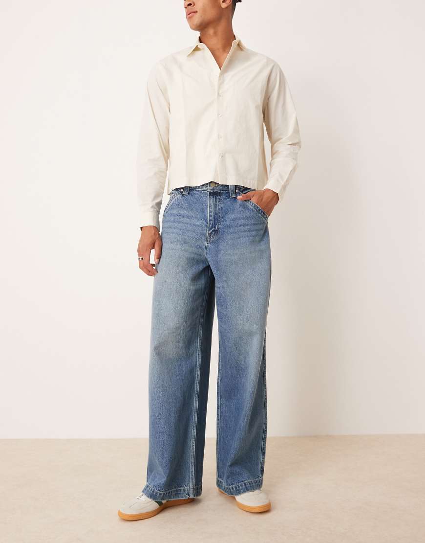 ASOS DESIGN - Super weite Jeans in mittelblauer Waschung mit bestickter Gesäßtasche von ASOS DESIGN