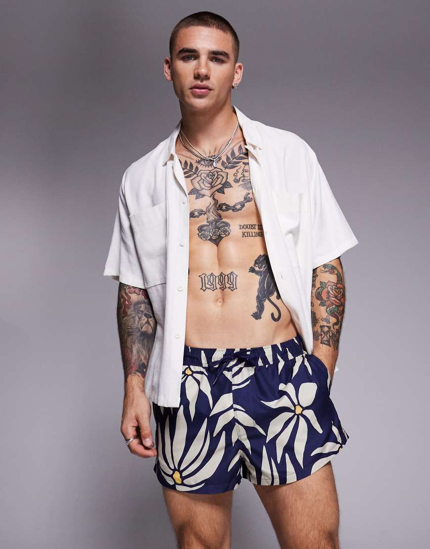 ASOS DESIGN - Superkurze Badeshorts in Marineblau mit Gänseblümchen-Muster von ASOS DESIGN
