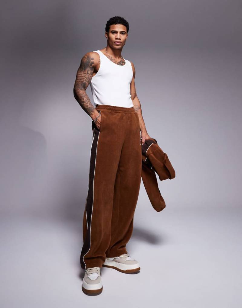 ASOS DESIGN - Superweite Jogginghose aus braunem Fleece mit Bahnendesign, Kombiteil von ASOS DESIGN