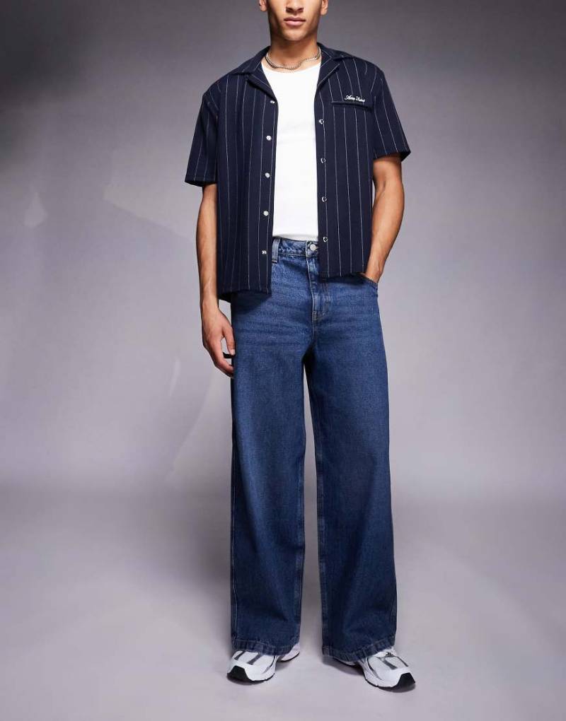 ASOS DESIGN - Superweite Jeans in dunkelblauer Waschung von ASOS DESIGN