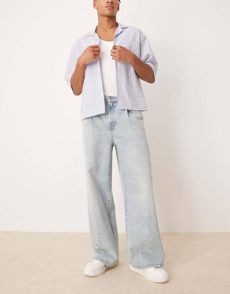 ASOS DESIGN - Superweite Jeans in hellblauer Waschung mit Bundfalten vorne von ASOS DESIGN