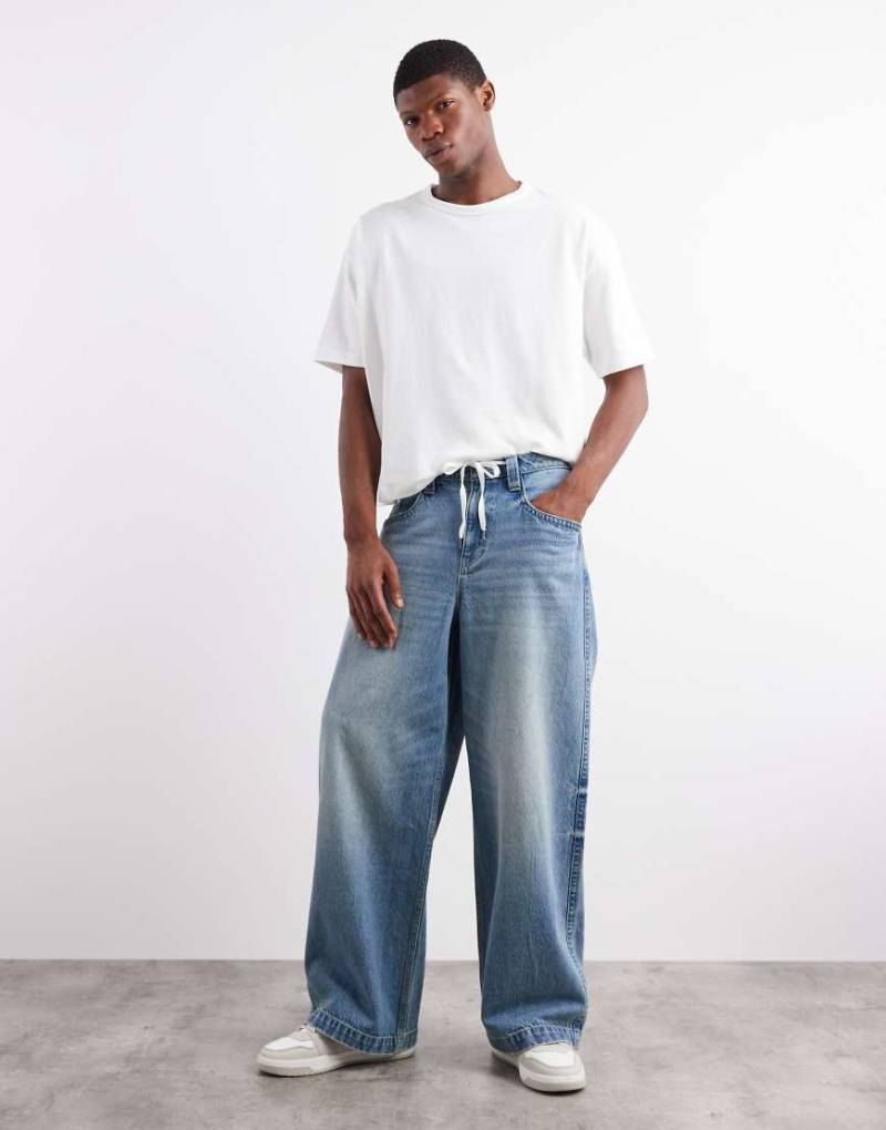 ASOS DESIGN - Superweite Jeans in hellblauer Waschung mit bestickten Gesäßtaschen von ASOS DESIGN