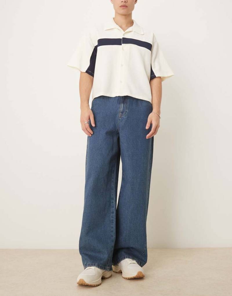 ASOS DESIGN - Superweite Jeans in mittelblauer Waschung mit verdrehten Nähten-Marineblau von ASOS DESIGN