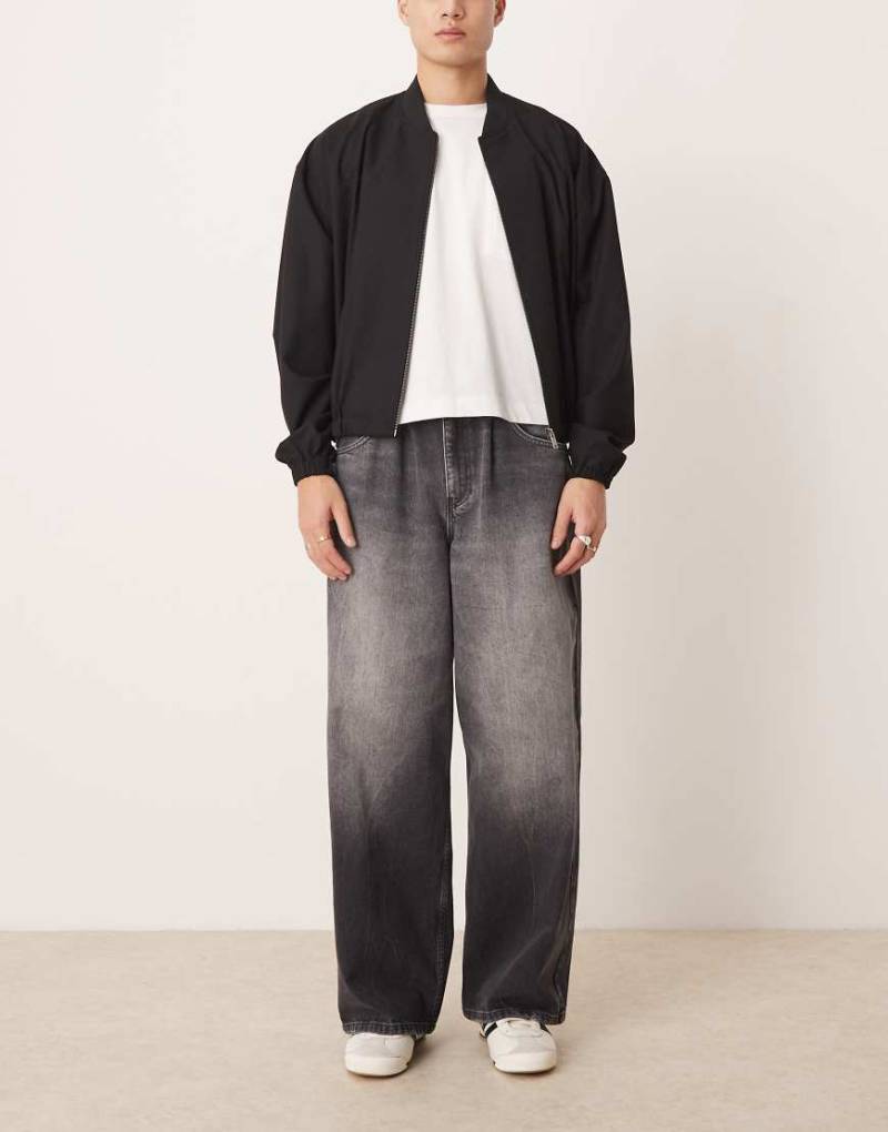 ASOS DESIGN - Superweite Jeans in schwarzer Waschung mit Kordelzugbund von ASOS DESIGN