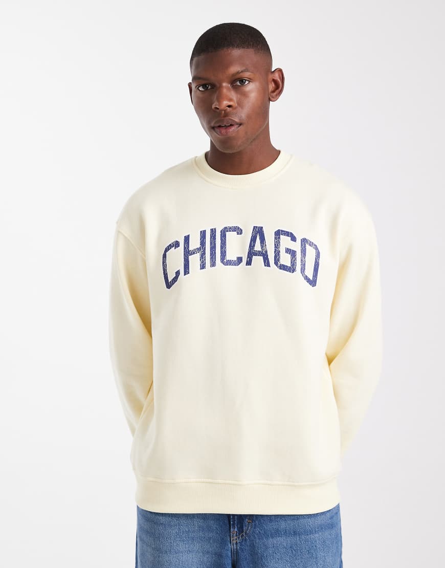 ASOS DESIGN - Sweatshirt in Blassgelb mit Schriftzug auf der Brust in abgenutzter Optik von ASOS DESIGN