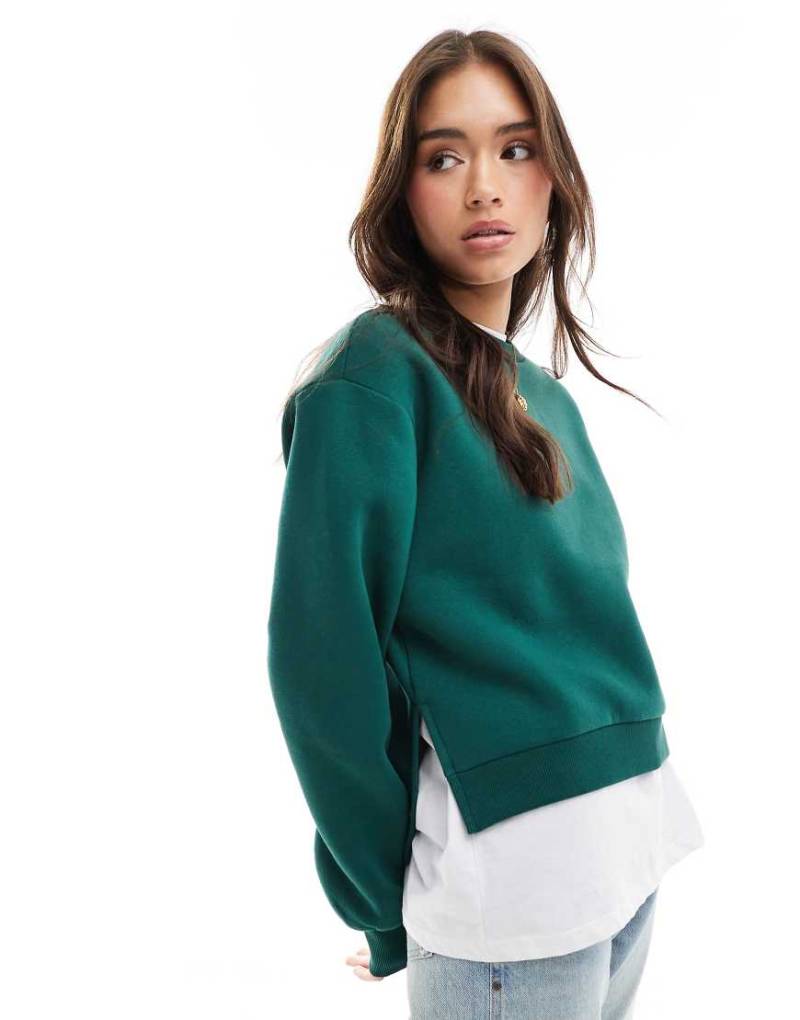 ASOS DESIGN - Sweatshirt in Tannengrün mit gestuftem Saum von ASOS DESIGN