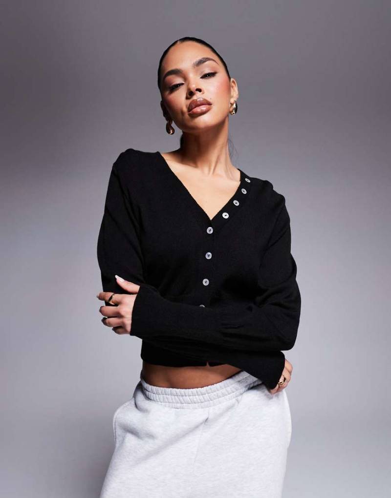 ASOS DESIGN - Taillierte Strickjacke in Schwarz mit Knöpfen in Muscheloptik von ASOS DESIGN