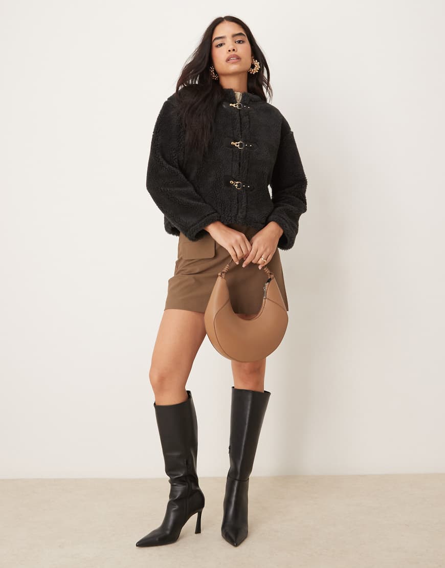ASOS DESIGN - Teddyfell-Jacke in Schwarz mit Schnallendetails ASOS DESIGN - Teddyfell-Jacke in Schwarz mit Schnallendetails von ASOS DESIGN