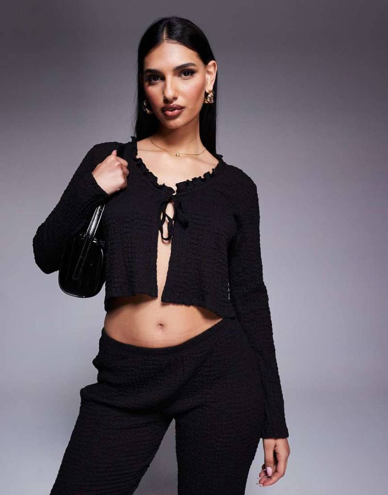 ASOS DESIGN - Texturiertes langärmeliges Oberteil in Schwarz mit weitem Ausschnitt, Rüschenkante und Schnürung vorn, Kombiteil ASOS DESIGN - Texturiertes langärmeliges Oberteil in Schwarz mit weitem Ausschnitt, Rüschenkante und Schnürung vorn, Kombiteil von ASOS DESIGN