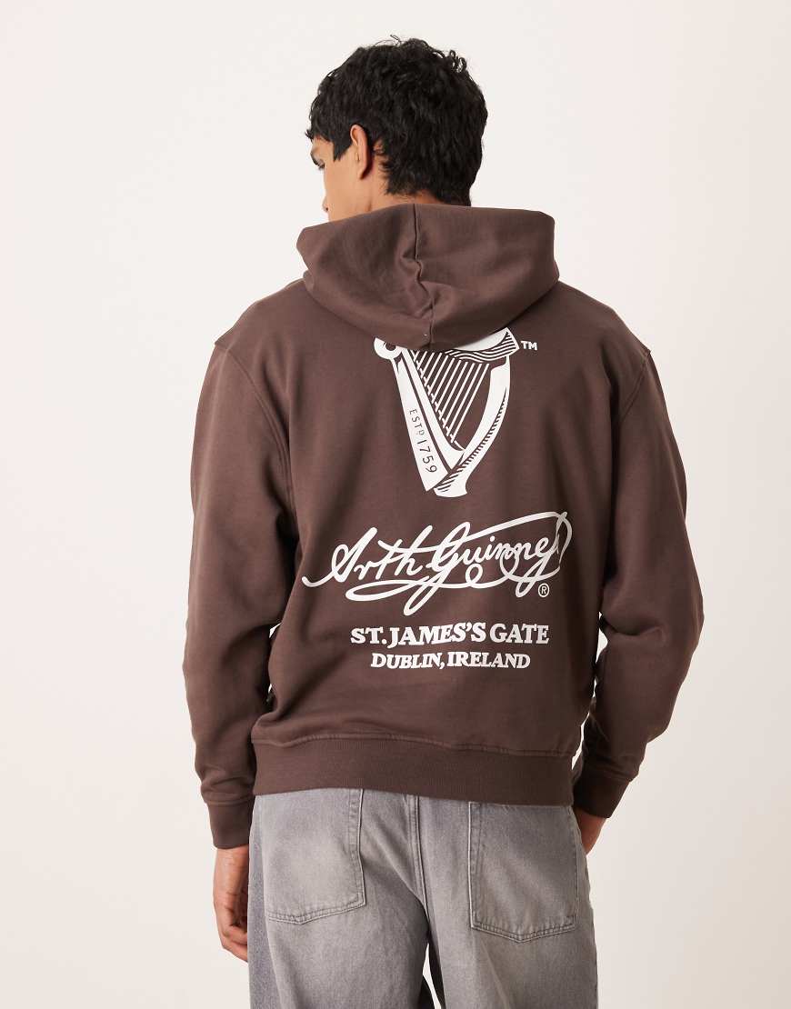 ASOS DESIGN - Unisex-Kapuzenpullover in Braun mit „Guinness"-Print und Oversize-Schnitt-Brown von ASOS DESIGN