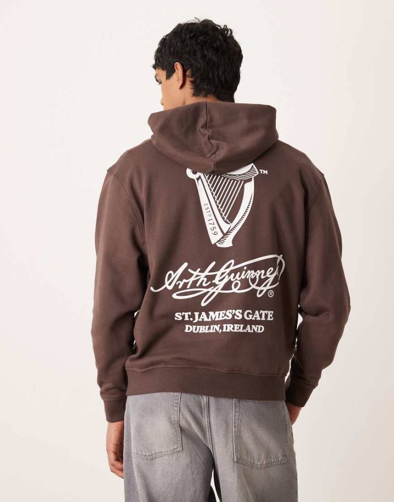 ASOS DESIGN - Unisex-Kapuzenpullover in Braun mit „Guinness"-Print und Oversize-Schnitt-Brown von ASOS DESIGN