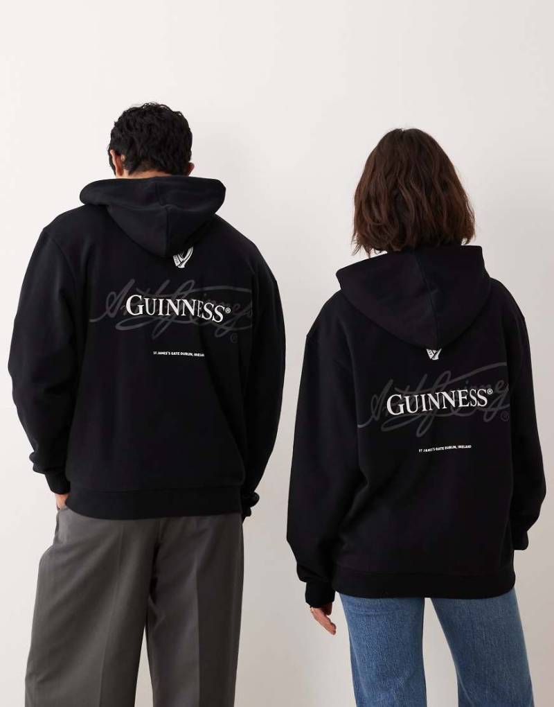 ASOS DESIGN - Unisex-Kapuzenpullover in Schwarz mit lizenzierten „Guinness"-Prints und Relaxed-Fit-Design von ASOS DESIGN