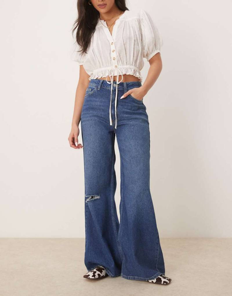 ASOS DESIGN - Weiche Jeans in leuchtendem Mittelblau mit weitem Beinschnitt und Zierrissen von ASOS DESIGN