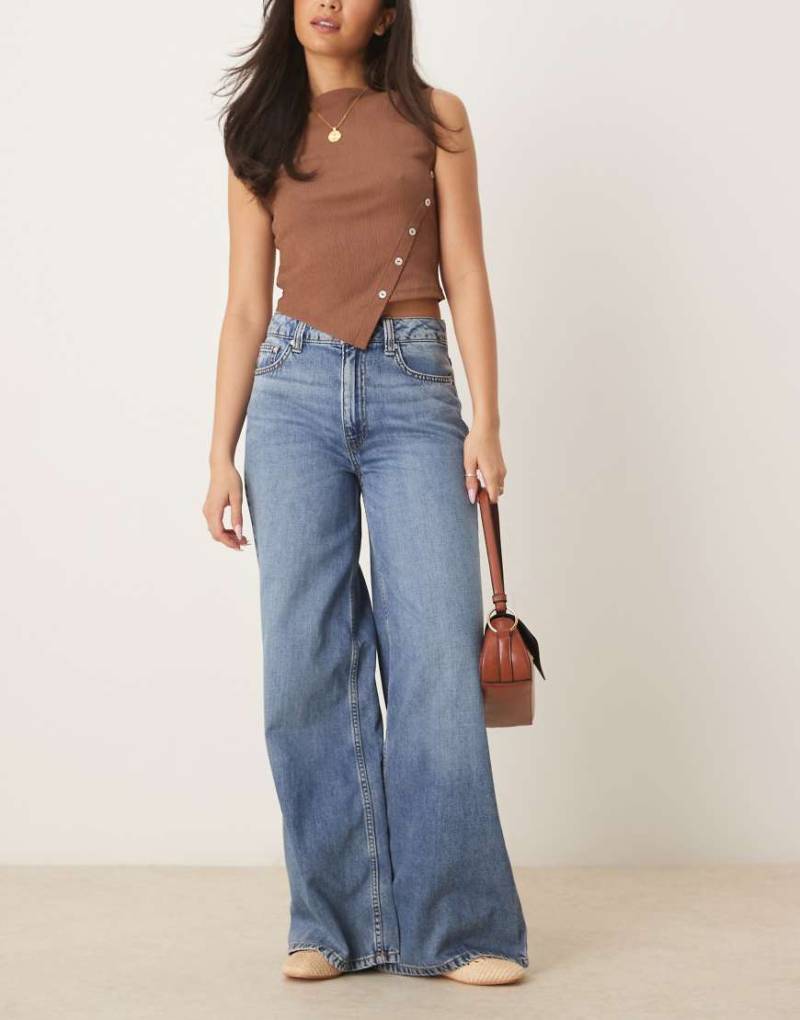 ASOS DESIGN - Weit geschnittene Jeans in verwaschenem Mittelblau von ASOS DESIGN
