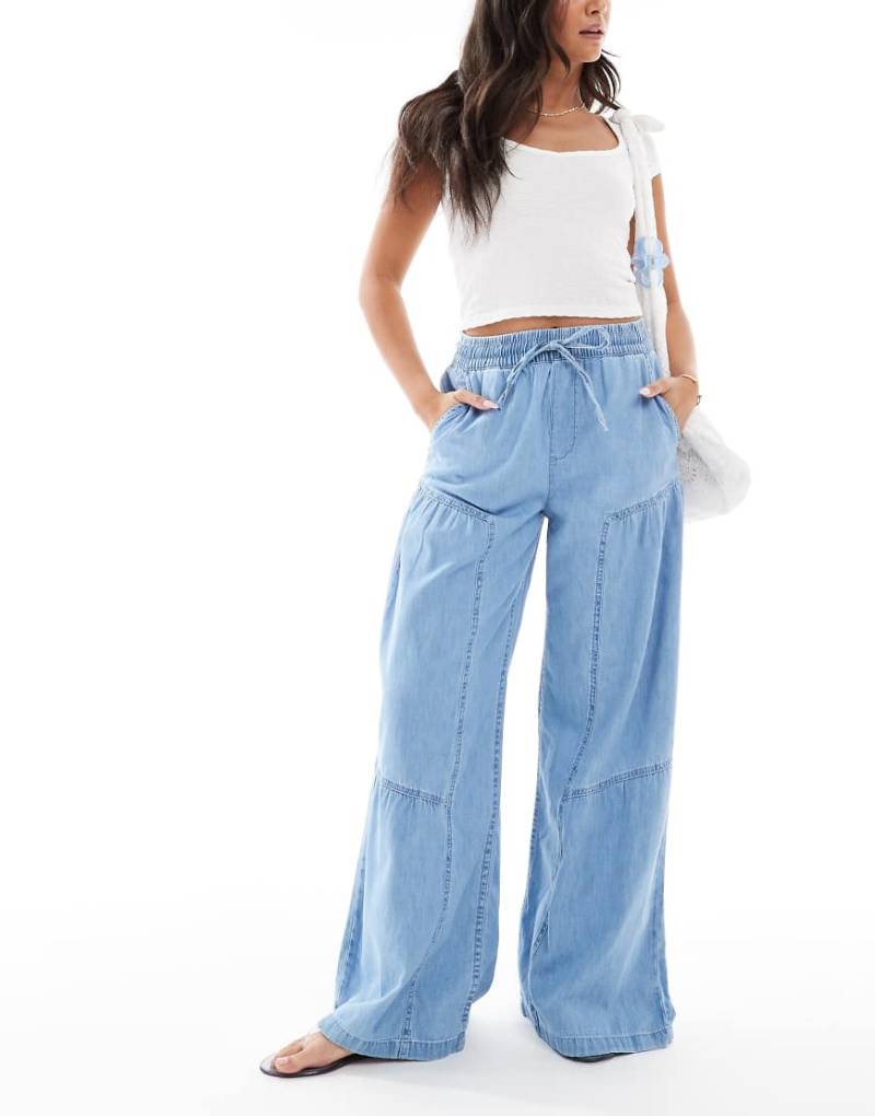 ASOS DESIGN - Weiche Jeans zum Hineinschlüpfen in Mittelblau mit Nahtdetails und weitem Bein von ASOS DESIGN