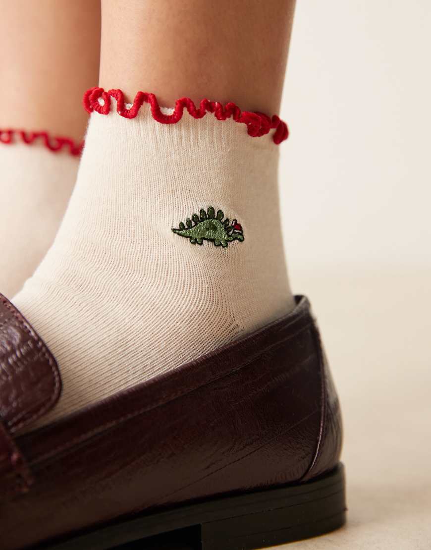 ASOS DESIGN - Weihnachtliche Socken in Cremeweiß mit Dinosaurier-Motiv ASOS DESIGN - Weihnachtliche Socken in Cremeweiß mit Dinosaurier-Motiv von ASOS DESIGN