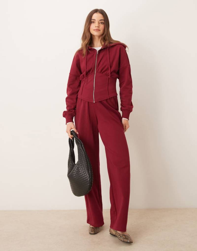 ASOS DESIGN - Weit geschnittene Jogginghose in Burgunderrot mit v-förmigem Bund von ASOS DESIGN