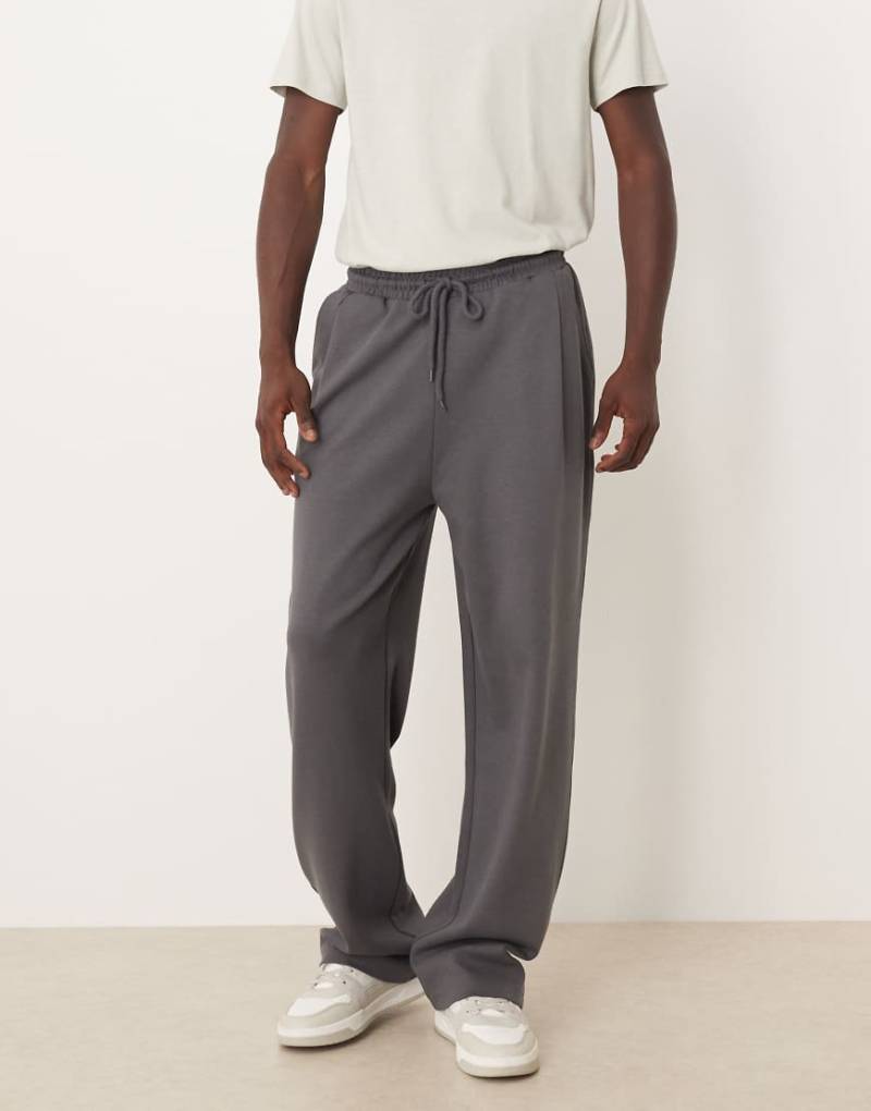 ASOS DESIGN - Weit geschnittene Jogginghose in Dunkelgrau mit Bundfalten von ASOS DESIGN