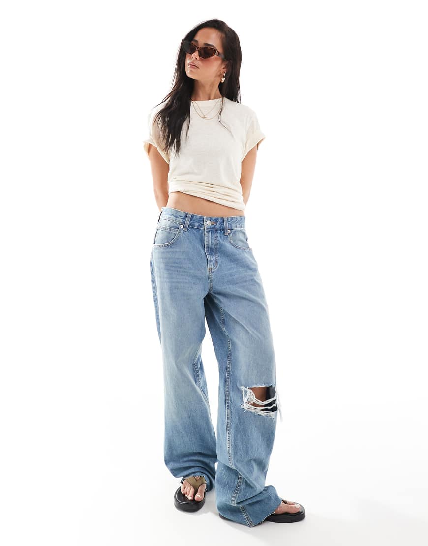 ASOS DESIGN - Weite Jeans in Mittelblau mit Zierrissen und niedrigem Bund von ASOS DESIGN