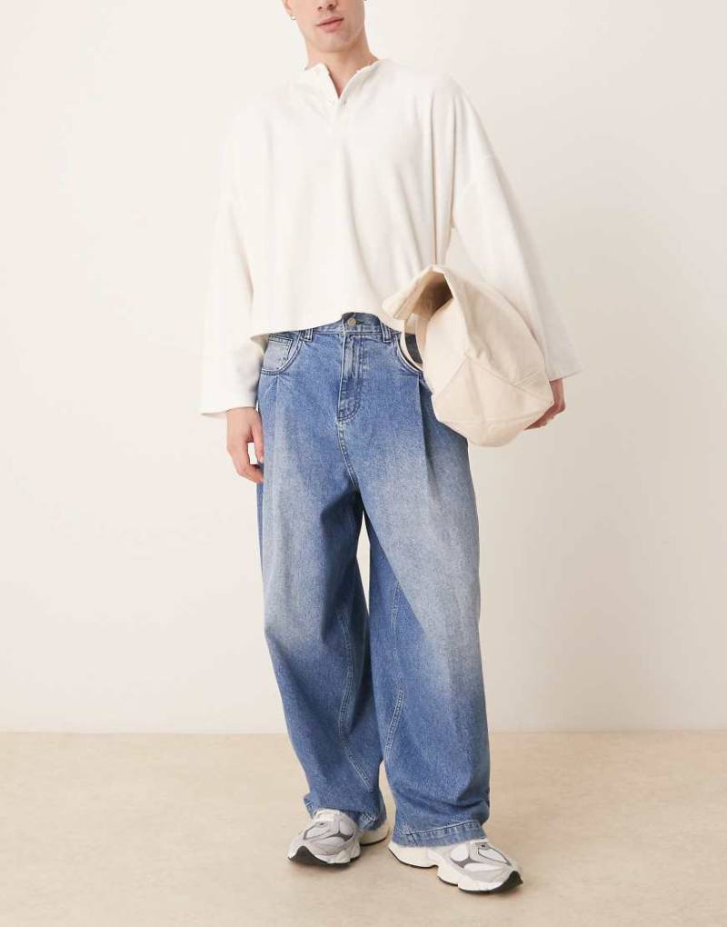 ASOS DESIGN - Weite Oversize-Jeans in verwaschenem Mittelblau mit Falten an den Taschen von ASOS DESIGN