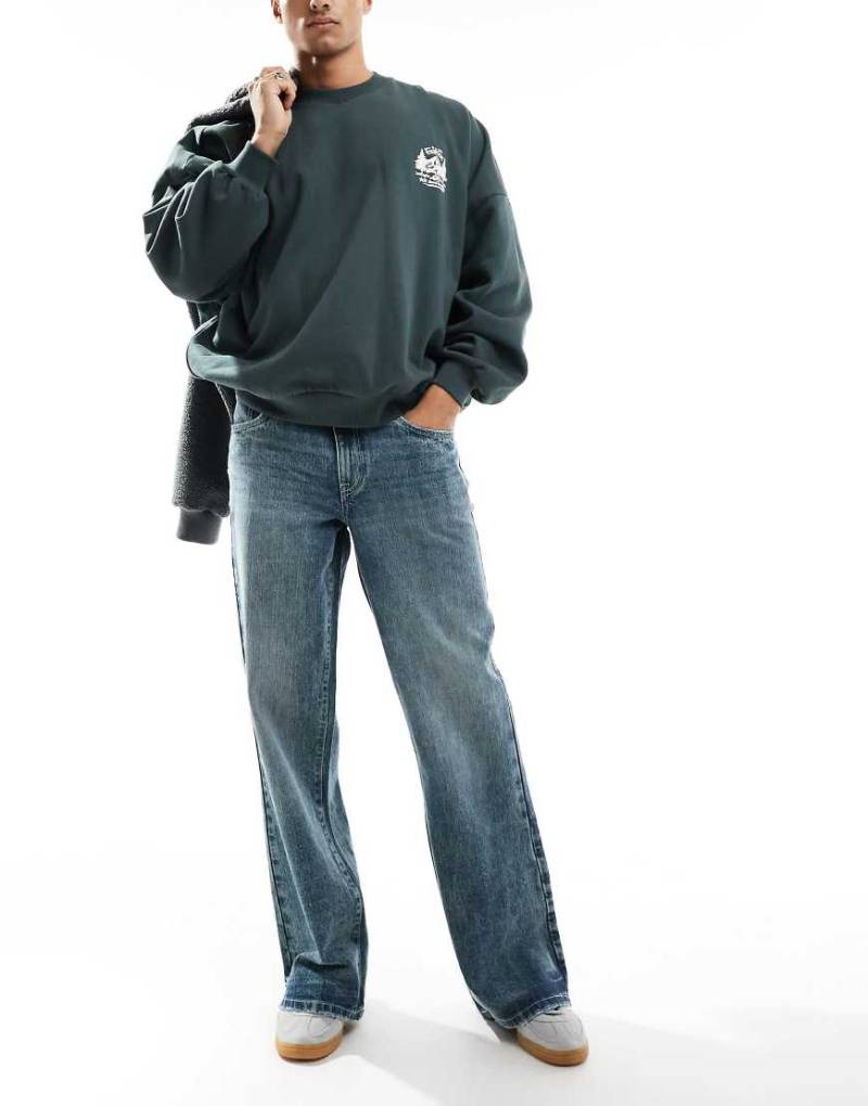 ASOS DESIGN - Weite Schlagjeans in graublauer Waschung von ASOS DESIGN