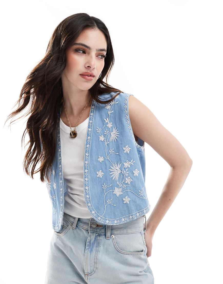 ASOS DESIGN - Weste aus weichem Denim in Mittelblau mit Stickerei ASOS DESIGN - Weste aus weichem Denim in Mittelblau mit Stickerei von ASOS DESIGN