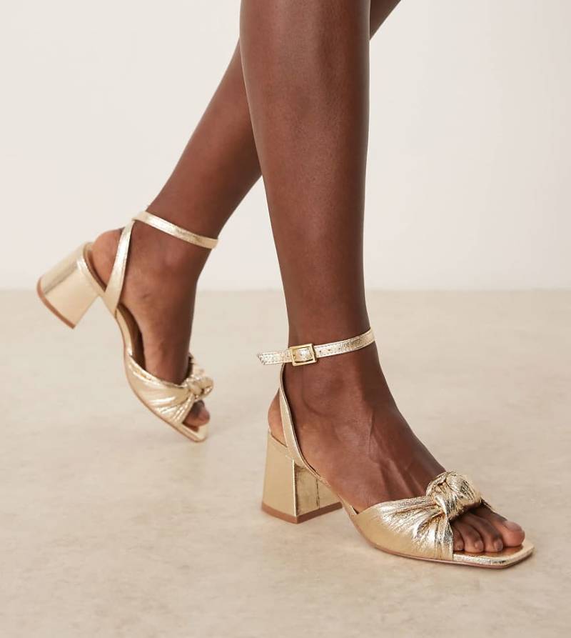 ASOS DESIGN Wide Fit - Hansel - Sandaletten in Gold mit Zierknoten und mittelhohem Absatz, weite Passform-Goldfarben von ASOS DESIGN