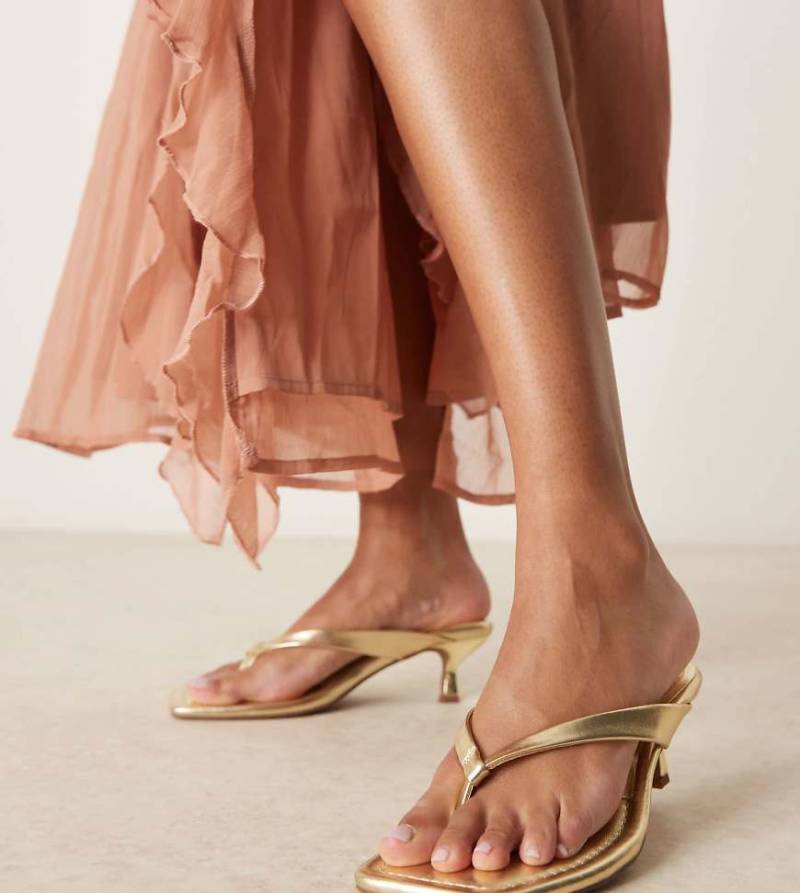 ASOS DESIGN Wide Fit - Hawaii - Sandaletten in Gold mit Zehensteg und Kitten-Absatz, weite Passform-Goldfarben von ASOS DESIGN Wide Fit