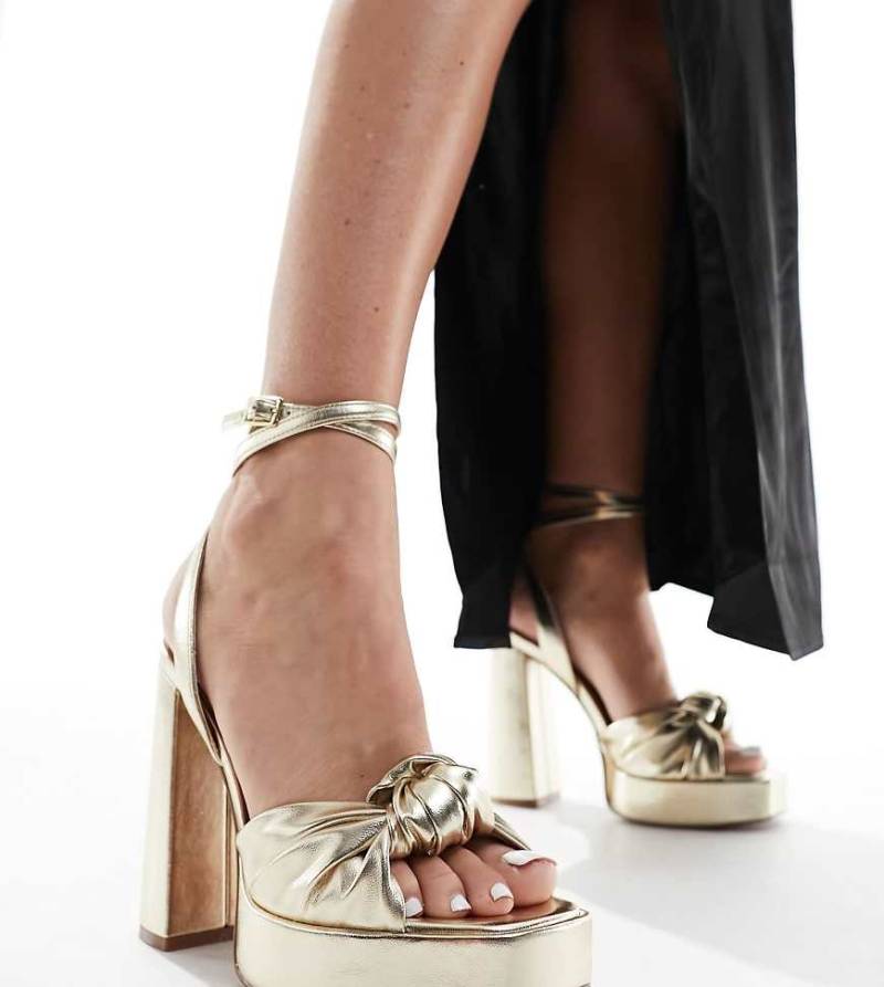 ASOS DESIGN Wide Fit - Nikita - Plateau-Sandaletten in Gold mit Absatz und Zierknoten-Goldfarben von ASOS DESIGN Wide Fit