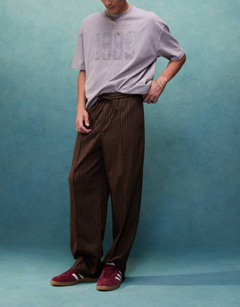 In ASOS DESIGN - Elegante Jogginghose zum Hineínschlüpfen in Braun mit Nadelstreifen und weitem Schnitt von ASOS DESIGN